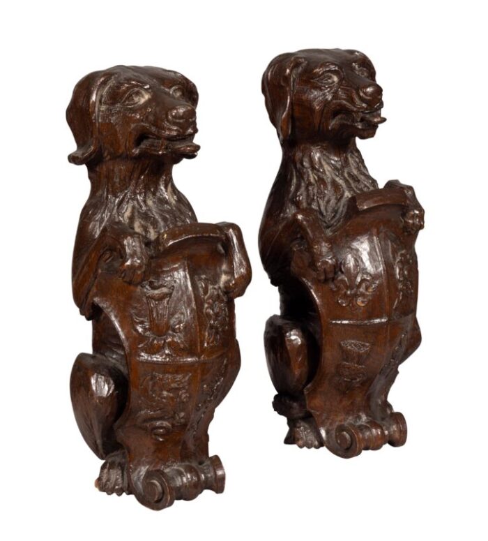 carved oak figures of seated dogs with shields a pair 4393