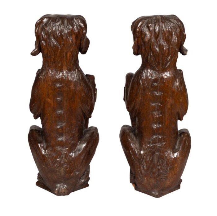 carved oak figures of seated dogs with shields a pair 6943